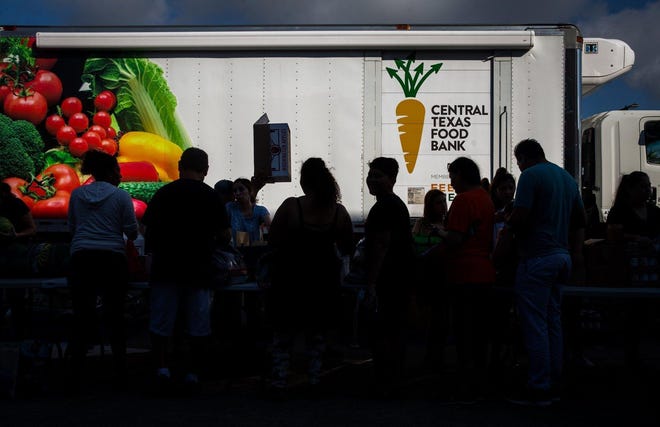 People form a line to receive food at a Central Texas Food Bank mobile food pantry in Kyle on August 17. [ELI IMADALI/AMERICAN-STATESMAN]