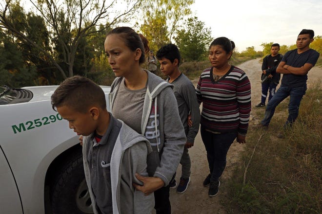 Migrants in McAllen, Texas, wait to be transported to a detention center. [Carolyn Cole/Los Angeles Times/TNS]