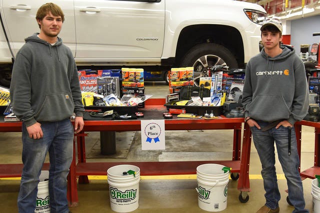 Boone High School students Ty Mechura (left) and Jonathan Kraus, both of Boone, stand in front of the prizes they won for taking sixth place in the hands-on portion of the 28th annual Des Moines Area Community/Iowa Automobile Dealers Association (IADA) Automotive Skills Contest recently held at the DMACC Ankeny Campus. | Photo by Dan Ivis of DMACC
