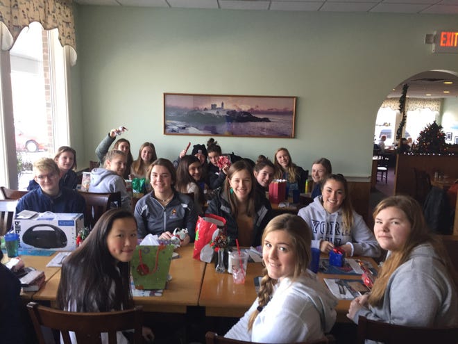 Members of the York/Traip/Marshwood girls hockey team gather during one of their Saturday morning team breakfasts at a local restaurant. The team got together and collected a variety of items to help a family in need this holiday season. [Courtesy photo]