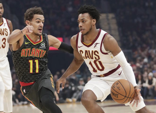 The Cavaliers' Darius Garland (10) drives past the Atlanta Hawks' Trae Young (11) in the first half Monday in Cleveland. [TONY DEJAK/THE ASSOCIATED PRESS]