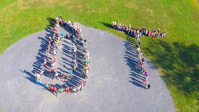 With word of the Davis Thayer School viability study this fall, the school community gathered for an aerial photo of students, teachers and others, standing in the shape of the letters "D" and "T" as a bonding moment and a show of support for their school. [Courtesy photo/Nicholas Bailey]