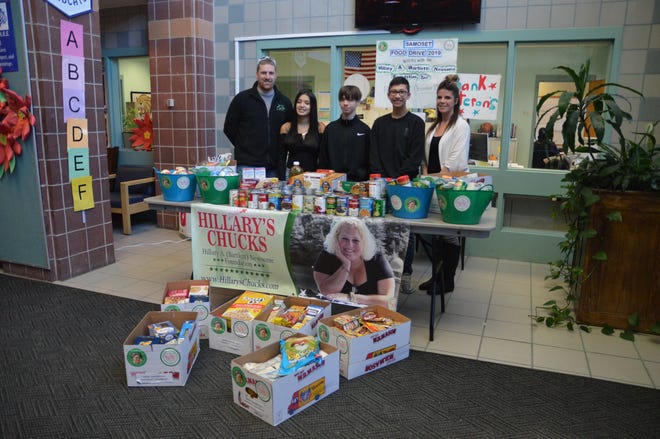 From left, Nick Bartlett, eighth-graders Maryanalee Muniz, Giovani Valeri and Jacob Russell, and eighth-grade teacher Katelyn Henrie stand behind the more than 500 items collected during the school’s third annual food drive done in coordination with the Hillary A. (Bartlett) Newsome Foundation. [DAVID DORE PHOTO]