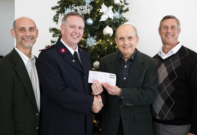 The News Herald's Rob Delaney, Salvation Army Maj. Ed Binnix, Bill Cramer and Bay County Commissioner Bill Dozier pose for a portrait with a donation to the Empty Stocking Fund on Monday. [JOSHUA BOUCHER/THE NEWS HERALD]