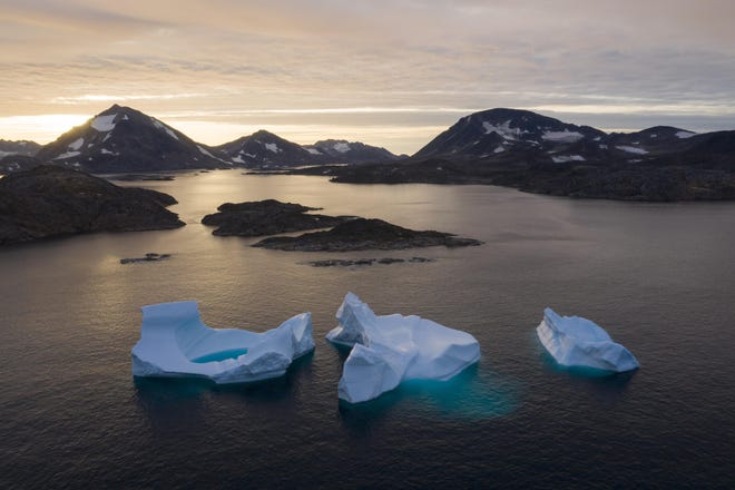 FILE - In this Aug. 16, 2019, file photo, large icebergs float away as the sun rises near Kulusuk, Greenland. Rising temperatures and diminished snow and ice cover in the Arctic are imperiling ecosystems, fisheries and local cultures, according to a report issued Tuesday, Dec. 10 by the National Oceanic and Atmospheric Administration. [AP Photo/Felipe Dana, File]