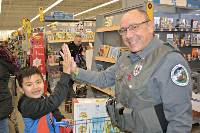 A Richland police officer takes a child shopping during Quakertown police’s “Shop with a Cop,” at the Walmart in Richland on Dec. 12. [PHOTO COURTESY OF QUAKERTOWN BOROUGH]