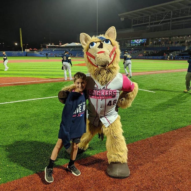 Caleb McNeill and the High Point Rockers mascot, Hype, pose after they raced around the bases. The Real Men Wear Pink campaign kicked off in the summer at Rockers game, with the team announcing the 2019 participants, and ran through October. [Contributed photo]