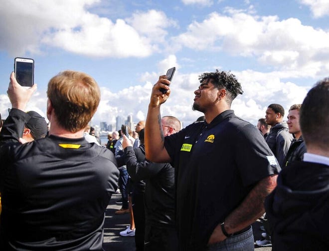 Iowa junior right tackle Tristan Wirfs snaps cell phone photos on the deck of the USS Theodore Roosevelt aircraft carrier Tuesday in Coronado, California. [Bryon Houlgrave/The Des Moines Register]