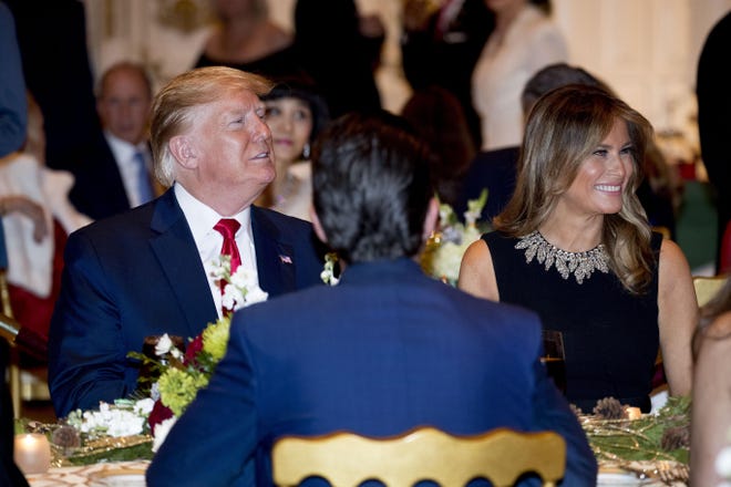 President Donald Trump and first lady Melania Trump arrive for Christmas Eve dinner at Mar-a-lago on Tuesday in Palm Beach. Donald Trump Jr., the son of President Donald Trump, is pictured in foreground. [Andrew Harnik/The Associated Press]