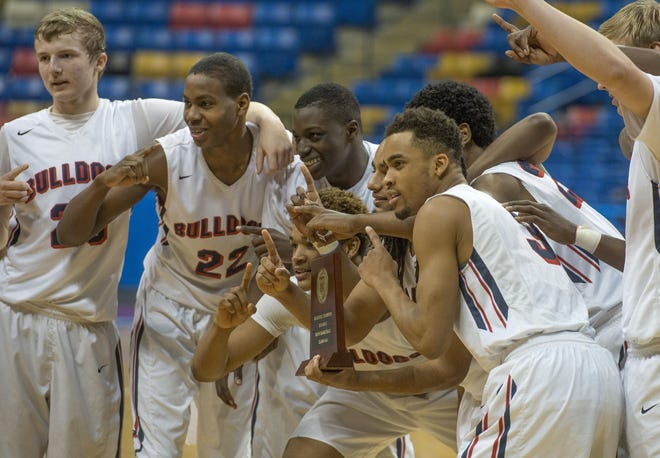 Terry Sanford basketball players hold the Eastern Regional Championship plaque after defeating Wilson Hunt to reach the state title game. The Bulldogs defeated Gastonia Ashbrook 67-60 to claim the 2015 state championship. [THE FAYETTEVILLE OBSERVER FILE PHOTO]