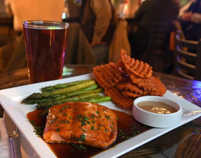 An entree of teriyaki salmon, sweet potato fries, asparagus and accompanying dipping sauce is shown Friday at Lakelands Restaurant and Pub in Girard Township. The dish is paired with a glass of Christmas Ale, background, left, by Great Lakes Brewing Co. of Cleveland. [CHRISTOPHER MILLETTE/ERIE TIMES-NEWS]