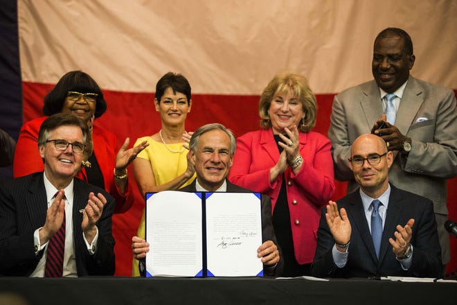 Gov. Greg Abbott signs into law House Bill 3, the sweeping school finance package, at Parmer Lane Elementary School in Austin on June 11. [LOLA GOMEZ/AMERICAN-STATESMAN]