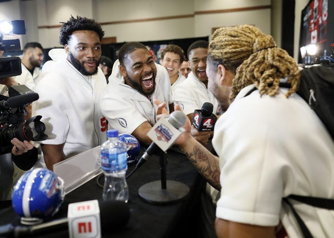 Ohio State defensive ends Tyler Friday, left, and Jonathon Cooper take a turn as media members as they interview defensive end Chase Young during Media Day for the Fiesta Bowl in Scottsdale, Ariz., on Thursday. [Adam Cairns/Dispatch]