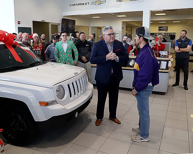 Joel Ferrier, Orr Auto Park variables operations manager, left, presents Brett McElhaney with the keys to his 2014 Jeep Patriot, Tuesday, Dec. 24, 2019, after McElhaney was named the recipient of the Orr Auto Park Car Giveaway. The Vian High School student was nominated for the second annual event by Dr. Logan Coffee, a Vian dentist. Vian "adopted" McElhaney following a string of family tragedies. [JAMIE MITCHELL/TIMES RECORD]