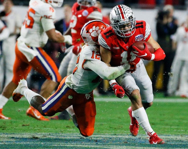 Ohio State Buckeyes wide receiver Austin Mack (11) fights for extra yards after a reception as Clemson Tigers safety K'Von Wallace (12) tackles during the fourth quarter of the College Football Playoff Semifinal at the PlayStation Fiesta Bowl between the Ohio State Buckeyes and the Clemson Tigers on Saturday, December 28, 2019 at State Farm Stadium in Glendale, Arizona.