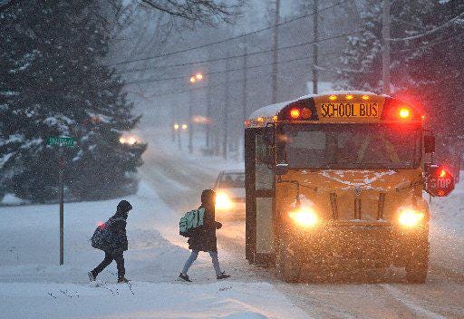 Children board a school bus on Old Ridge Road at Shauna Avenue in Fairview Township amid a lake-effect snowstorm on Jan. 25. Despite a new state law, General McLane is the only school district in Erie County approved to use “flexible instructional days” that allow students to learn at home during snow days. [FILE PHOTO/ERIE TIMES-NEWS]