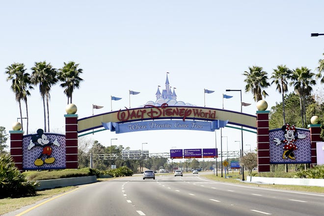 In this Jan. 31, 2017, file photo, cars travel one of the roads leading to Walt Disney World in Lake Buena Vista, Fla. Walt Disney World employees who portray Mickey Mouse, Minnie Mouse and Donald Duck each filed police reports this month, Dec. 2019, claiming they were inappropriately touched by tourists. The woman inside the Mickey Mouse costume went to the hospital with neck injuries caused by a grandmother patting the character's head, while the employees wearing the Minnie Mouse and Donald Duck costumes were groped by tourists, according to Orange County Sheriff's Office reports.(AP Photo/John Raoux, File)