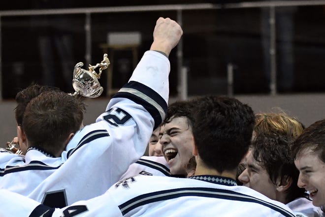 Framingham senior goalkeeper Jake Handy (center) celebrates with the team after the Flyers defeated Xaverian in a shootout during the MHL Cup championship game at Loring Arena in Framingham on Saturday. Handy was named the MVP of the game. [Daily News and Wicked Local Staff Photos/John Walker]