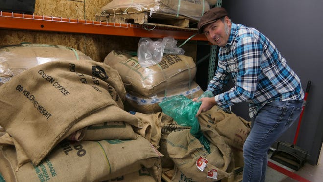 Jason Hendry, wholesale general manager at Reverie Roasters in Wichita, examines a batch of unroasted Harra hand-packed Ethiopian coffee beans for Tiru Coffee. [Alice Mannette/HutchNews]