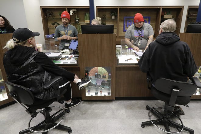 In this Thursday, Dec. 26, 2019 photo, registered medical marijuana patients talk with staff members at the Rise cannabis store in Mundelein, Ill. Starting Jan. 1, 2020, Illinois will join Michigan as the only Midwestern states broadly allowing the sale and use of marijuana. (AP Photo/Nam Y. Huh)