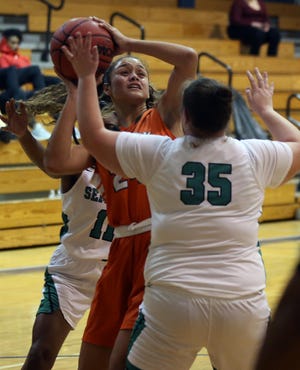 Mosley's Mya Colston shoots the ball in between a pair of Seminole County defenders in Monday’s game at the Marlin Christmas Classic. [PATTI BLAKE/THE NEWS HERALD]