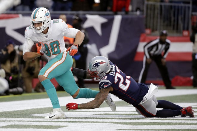 Miami Dolphins tight end Mike Gesicki, left, catches the winning touchdown pass in front of New England Patriots safety Patrick Chung in the second half of an NFL football game, Sunday, Dec. 29, 2019, in Foxborough, Mass. [AP Photo/Elise Amendola]