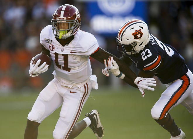 Alabama wide receiver Henry Ruggs III tries to break a tackle by Auburn defensive back Roger McCreary during the first half of their game at Jordan-Harie Stadium, Saturday, Nov. 30, 2019. [Staff Photo/Gary Cosby Jr.]