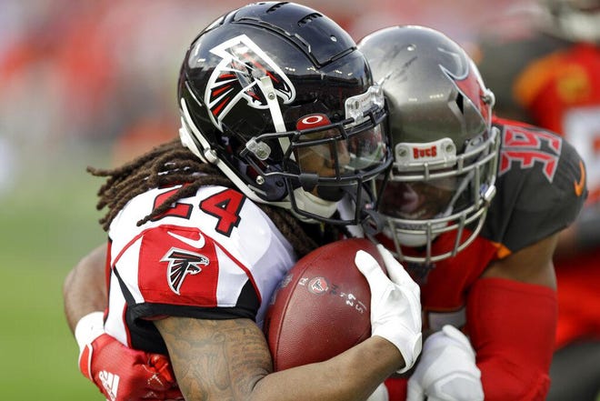 Atlanta Falcons running back Devonta Freeman (24) is stopped by Tampa Bay Buccaneers strong safety Andrew Adams (39) on a run during the first half of an NFL football game Sunday, Dec. 29, 2019, in Tampa, Fla. (AP Photo/Chris O'Meara)