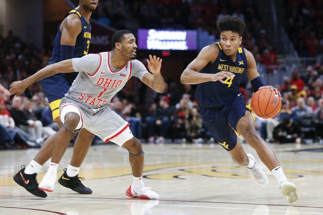 West Virginia's Miles McBride (4) drives on Ohio State's Luther Muhammad (1) during the second half of an NCAA college basketball game Sunday, Dec. 29, 2019, in Cleveland. West Virginia defeated Ohio State 67-59. (AP Photo/Ron Schwane)