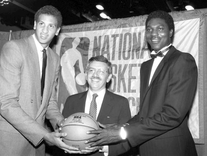 In this June 19, 1984 file photo, NBA commissioner David Stern (center) is flanked by Akeem Olajuwon (right) the No. 1 pick overall by the Houston Rockets, and Sam Bowie, the No. 2 pick overall by the Portland Trail Blazers, at the NBA Draft in New York. [Marty Lederhandler / Associated Press File]