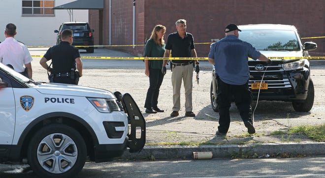 Investigators gather information at the scene of a Providence homicide in August, tagging and collecting shell casings on the ground. [The Providence Journal, file / Bob Breidenbach]
