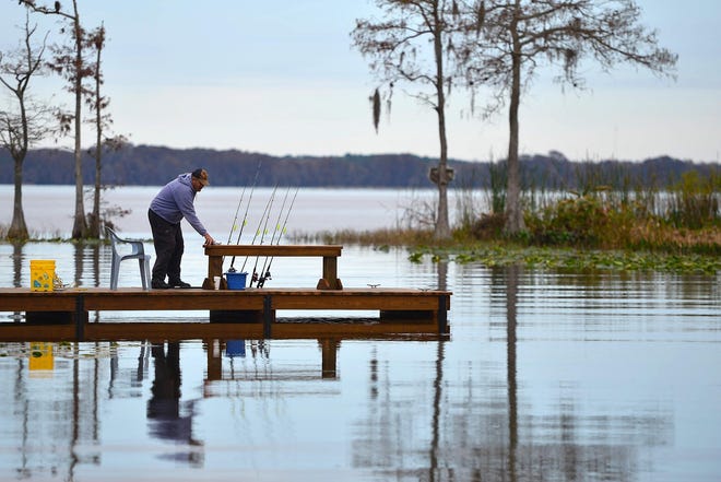 A man fishes from a dock on Lake Eustis in Tavares. [Daily Commercial file]