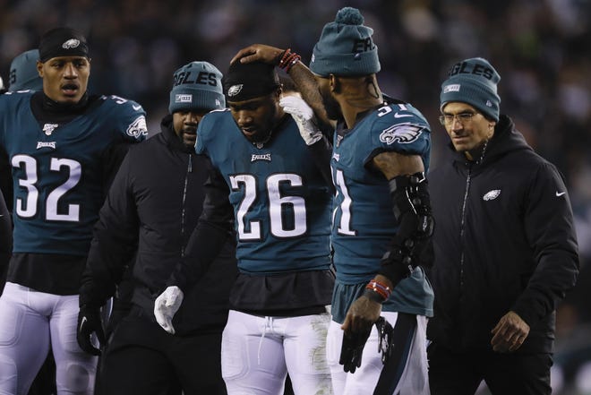 Eagles rookie running back Miles Sanders is helped off the field on the final play of the first half. [MICHAEL PEREZ / ASSOCIATED PRESS]