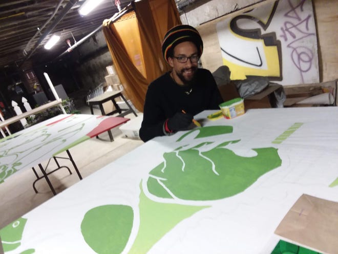 Eden Soares working on the last panels for his coming Cape Verdean Cultural Center mural. [Photo by Steven Froias]