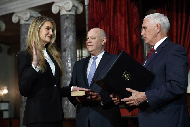 Sen. Kelly Loeffler, R-Ga.,, with her husband Jeffrey Sprecher, center, participates in a re-enactment of her swearing-in Monday, Jan. 6, 2020, by Vice President Mike Pence in the Old Senate Chamber on Capitol Hill in Washington. [AP Photo/Jacquelyn Martin]