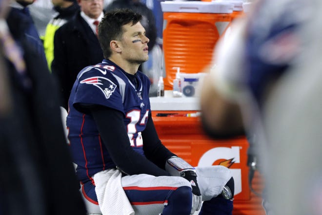 New England Patriots quarterback Tom Brady sits on the bench after throwing an interception that Tennessee Titans cornerback Logan Ryan returned for a touchdown late in the second half of an NFL wild-card playoff game Saturday night in Foxborough, Mass. The Titans eliminated the Patriots 20-13. [BILL SIKES/THE ASSOCIATED PRESS]