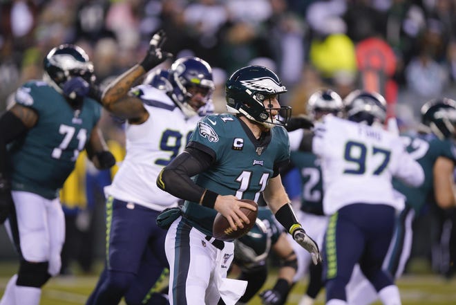 Eagles quarterback Carson Wentz looks for an open receiver during Sunday’s playoff loss to the Seahawks. [CHRIS SZAGOLA / ASSOCIATED PRESS]
