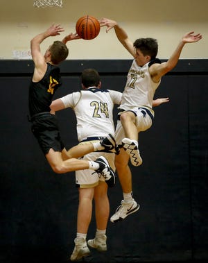Marist's Alec Vendetti (12) gets a piece of the ball but teammate Luke Eagen (24) gets a piece of Cascade guard Justus Bischoff and was called for a foul during the fourth quarter of the Spartans' 42-39 win at home Tuesday. [Andy Nelson/The Register-Guard] - registerguard.com