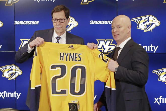 New Nashville Predators NHL hockey team head coach John Hynes, right, poses for photos with Predators general manager David Poile at a news conference Tuesday in Nashville, Tenn. The Predators hired Hynes, the former New Jersey Devils coach, as the third coach in franchise history after firing Peter Laviolette. [Mark Humphrey/The Associated Press]