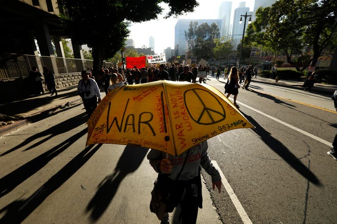 Kathleen Schwartz' umbrella asks the question, "war or peace," while joining around 300 people taking part in a day of protest, voicing their opposition to war with Iran, in Los Angeles on Saturday, Jan. 4, 2020. [Genaro Molina/Los Angeles Times/TNS]