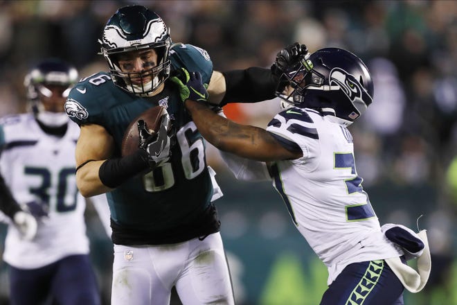 Eagles tight end Zach Ertz stiff-arms the Seahawks' Quandre Diggs during tlast Sunday’s playoff game. [JULIO CORTEZ / ASSOCIATED PRESS]