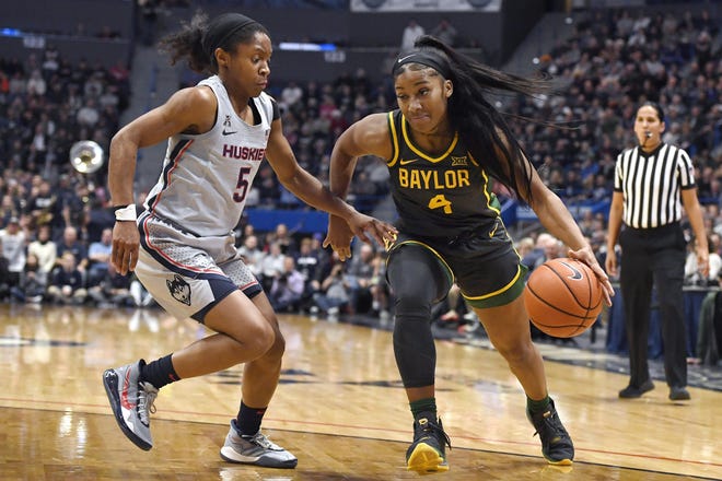 Baylor's Te'a Cooper, right, dribbles as Connecticut's Crystal Dangerfield, left, defends during the first half Thursday in Hartford, Conn. Baylor won 74-58. [Jessica Hill/The Associated Press]