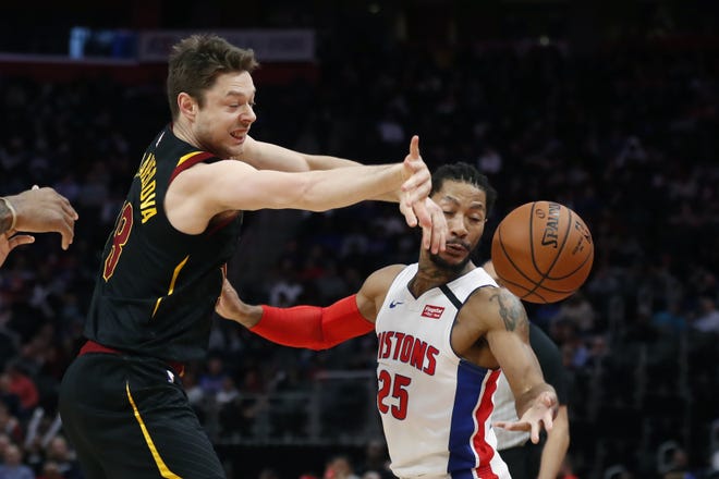 Cleveland Cavaliers guard Matthew Dellavedova (18) and Detroit Pistons guard Derrick Rose (25) reach for the ball during the first half of an NBA basketball game Thursday, Jan. 9, 2020, in Detroit. (AP Photo/Carlos Osorio)