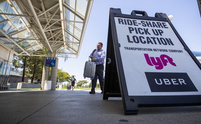 in this file photo, a traveler arrives in the ride-share pick up location at Ontario International Airport on Aug. 12, 2019 in Ontario, CA. It's fairly common for adults in back not to wear seat belts, especially when they're riding in taxis and ride-hailing vehicles such as Uber and Lyft. (Allen J. Schaben/Los Angeles Times/TNS)