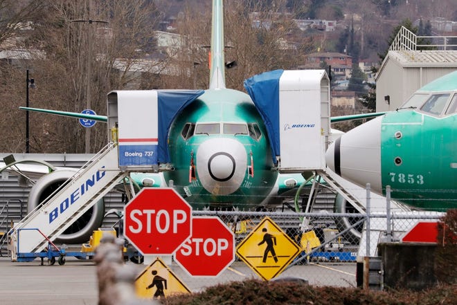 In this Monday, Dec. 16, 2019, file photo, Boeing 737 Max jets sit parked in Renton, Wash. Newly released Boeing documents show that company employees knew about problems with flight simulators for the now-grounded 737 Max jetliner and talked about misleading regulators. (AP Photo/Elaine Thompson, File)