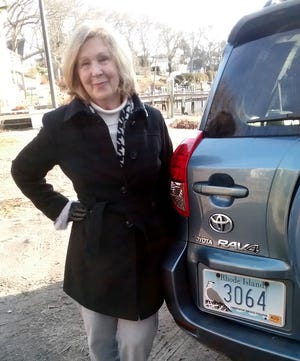 Christine MacManus with the license plate once belonging to Gladys Coggeshall, her husband's aunt and a lifelong resident of South Kingstown. [Courtesy of Christine MacManus]