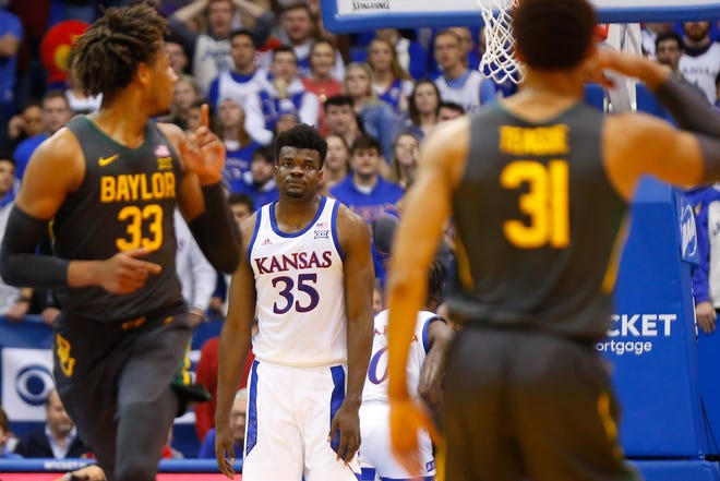 Kansas center Udoka Azubuike looks back to Baylor's MaCio Teague, right, and Freddie Gillespie after Teague drained a 3-pointer in the first half of Saturday's game inside Allen Fieldhouse in Lawrence. The Jayhawks lost 67-55 to the Bears. [Evert Nelson/The Capital-Journal]