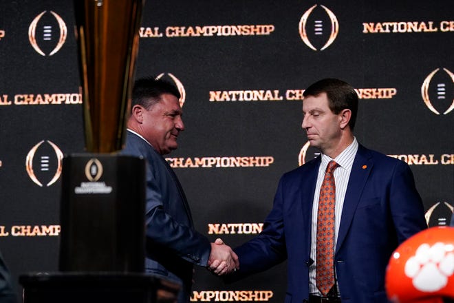 LSU head coach Ed Orgeron, left, and Clemson head coach Dabo Swinney shake hands after a news conference for the NCAA College Football Playoff national championship game Sunday, Jan. 12, 2020, in New Orleans. Clemson is scheduled to play LSU on Monday. (AP Photo/David J. Phillip).