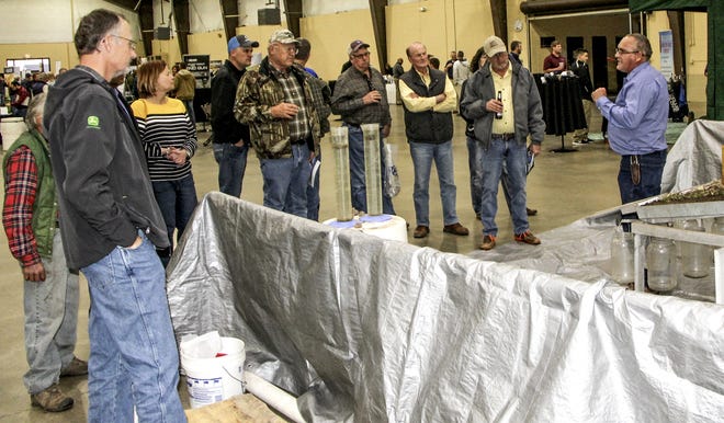 A USDA representative shares information on vertical tillage with area producers with help from an active display complete with "rain" impact on tilled land. The display was one of many at the Winter Water Technology Expo on Thursday at the Finney County Fairgrounds. [GALE ROSE/Garden City Telegram]