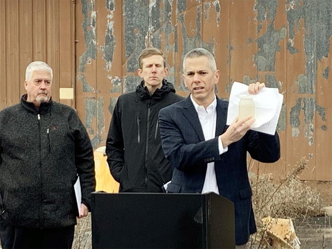 Congressman Anthony Brindisi holds a jar of contaminated water at a former state Department of Transportation salt storage facility in Vernon Center on Monday. [STEVE HOWE/OBSERVER-DISPATCH]